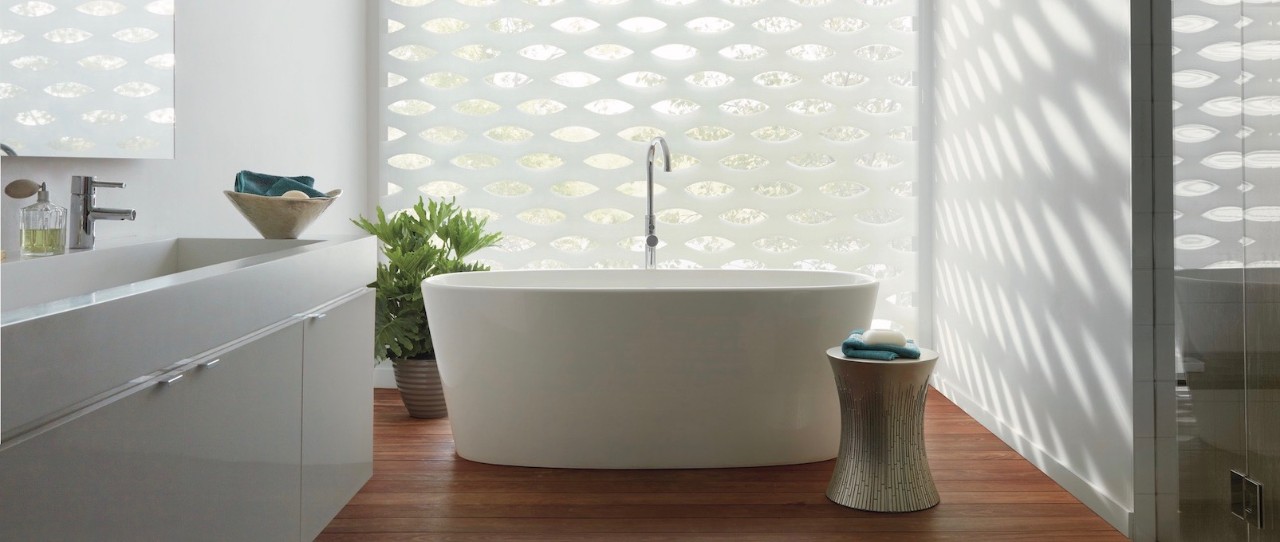 modern bathroom with oval tube in front of textured roller shades